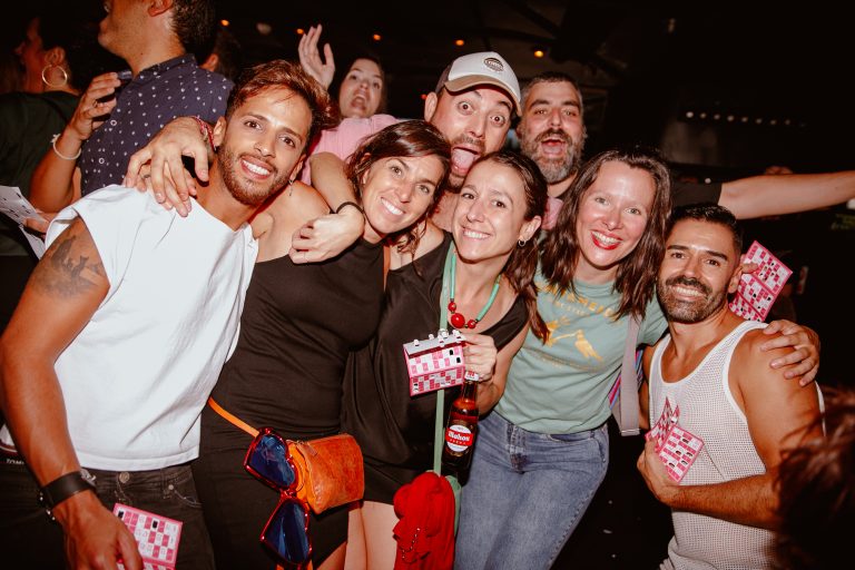 Amigos posando sonrientes con sus cartones de bingo musical en la fiesta Loco Bongo