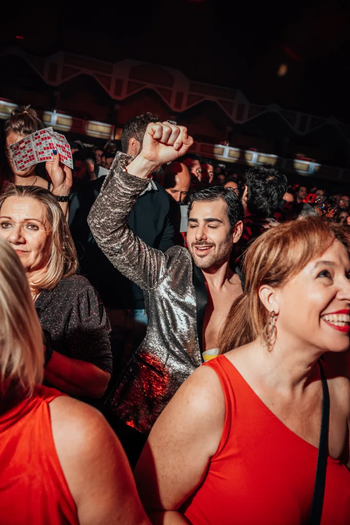 Amigos celebrando con el puño en alto entre el público de Loco Bongo